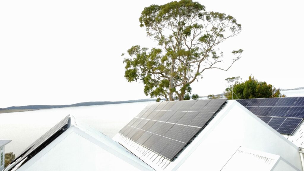Residential rooftop solar panel installation with a tree in the background
